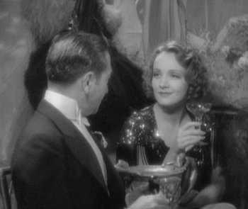 Movie still from “Morocco” (1930), directed by Josef von Sternberg – A man and a woman in formal wear at a party; Medium shot, High angle