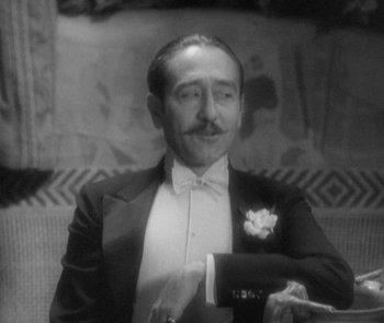 Movie still from “Morocco” (1930), directed by Josef von Sternberg – A man in a tuxedo sitting on a couch; Close Up shot, High angle