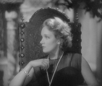 Movie still from “Morocco” (1930), directed by Josef von Sternberg – An old photo of a woman sitting in a chair; Close Up shot, High angle