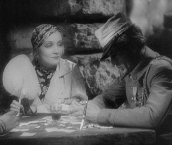 Movie still from “Morocco” (1930), directed by Josef von Sternberg – A man and a woman sitting at a table; Medium shot, High angle