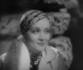 Movie still from “Morocco” (1930), directed by Josef von Sternberg – An old photo of a woman with a scarf around her head; Close Up shot, Over the shoulder angle