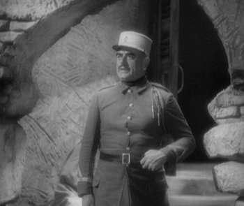 Movie still from “Morocco” (1930), directed by Josef von Sternberg – An old photo of a man in a military uniform; Medium shot, Low angle