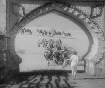 Movie still from “Morocco” (1930), directed by Josef von Sternberg – A black - and - white photo of a group of men on horses; Wide shot, High angle