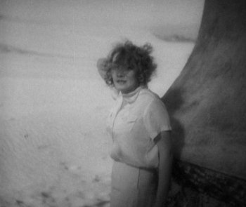 Movie still from “Morocco” (1930), directed by Josef von Sternberg – A woman standing next to a wall on the beach; Medium shot, High angle