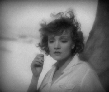 Movie still from “Morocco” (1930), directed by Josef von Sternberg – A black - and - white photo of a woman holding her hand to her face; Close Up shot, High angle
