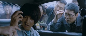 Movie still from “Mother” (2009), directed by Bong Joon Ho – A man sitting in the back seat of a car; Close Up shot, Over the shoulder angle
