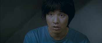 Movie still from “Mother” (2009), directed by Bong Joon Ho – A young man with a nose ring looking at the camera; Close Up shot, High angle