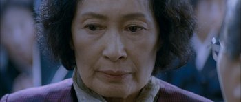 Movie still from “Mother” (2009), directed by Bong Joon Ho – An older woman is looking at the camera; Close Up shot, Low angle
