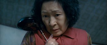 Movie still from “Mother” (2009), directed by Bong Joon Ho – An older woman holding a cell phone in her right hand; Close Up shot, High angle