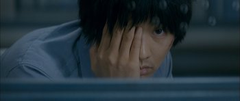 Movie still from “Mother” (2009), directed by Bong Joon Ho – A person with their hands over their face; Extreme Close Up shot, Overhead angle