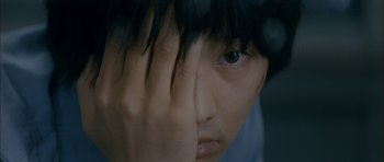 Movie still from “Mother” (2009), directed by Bong Joon Ho – A person with his hand over his face; Extreme Close Up shot, Overhead angle