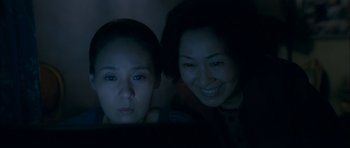 Movie still from “Mother” (2009), directed by Bong Joon Ho – Two women looking at a computer screen in the dark; Close Up shot, High angle