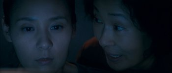 Movie still from “Mother” (2009), directed by Bong Joon Ho – Two women looking at the camera in the dark; Close Up shot, Overhead angle