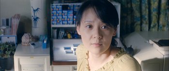 Movie still from “Mother” (2009), directed by Bong Joon Ho – A woman in a yellow shirt in front of an open refrigerator; Close Up shot, Over the shoulder angle