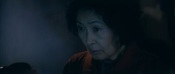 Movie still from “Mother” (2009), directed by Bong Joon Ho – An older woman is looking at the camera; Close Up shot, Low angle