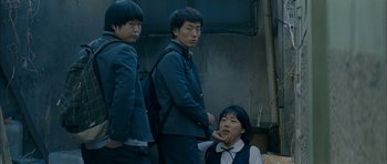 Movie still from “Mother” (2009), directed by Bong Joon Ho – A group of young men standing next to each other on a street; Medium shot, Low angle