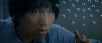 Movie still from “Mother” (2009), directed by Bong Joon Ho – A young man looking through a glass window; Extreme Close Up shot, High angle