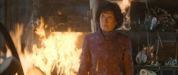 Movie still from “Mother” (2009), directed by Bong Joon Ho – An older woman standing in front of a fireplace; Medium shot, Over the shoulder angle