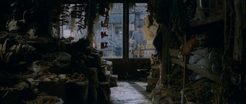 Movie still from “Mother” (2009), directed by Bong Joon Ho – A man standing in front of a store window; Wide shot, High angle