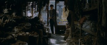 Movie still from “Mother” (2009), directed by Bong Joon Ho – A man standing in front of an open door in a store; Wide shot, High angle