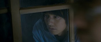 Movie still from “Mother” (2009), directed by Bong Joon Ho – A man looking out of a window at night; Close Up shot, High angle