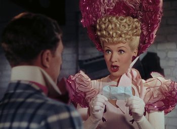 Movie still from “Mother Wore Tights” (1947), directed by Walter Lang – A woman in a pink dress and a man in a black and white checkered shirt; Medium shot, Over the shoulder angle