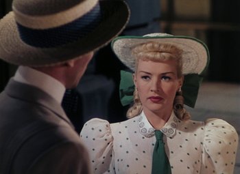 Movie still from “Mother Wore Tights” (1947), directed by Walter Lang – A man and a woman wearing hats and a dress; Close Up shot, Over the shoulder angle