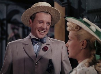 Movie still from “Mother Wore Tights” (1947), directed by Walter Lang – A man and a woman wearing hats and smiling; Close Up shot, Over the shoulder angle