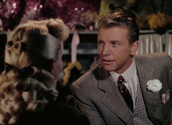 Movie still from “Mother Wore Tights” (1947), directed by Walter Lang – A man in a suit talking to a woman in a dress suit; Close Up shot, Over the shoulder angle