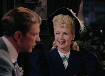 Movie still from “Mother Wore Tights” (1947), directed by Walter Lang – A man and a woman wearing a green hat; Medium shot, Over the shoulder angle