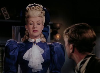 Movie still from “Mother Wore Tights” (1947), directed by Walter Lang – A woman in a blue dress and a man in a black suit; Close Up shot, Over the shoulder angle