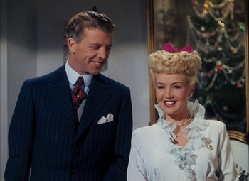 Movie still from “Mother Wore Tights” (1947), directed by Walter Lang – A man and a woman standing next to a christmas tree; Medium shot, Low angle