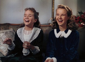 Movie still from “Mother Wore Tights” (1947), directed by Walter Lang – Two young girls sitting next to each other on a couch; Medium shot, High angle