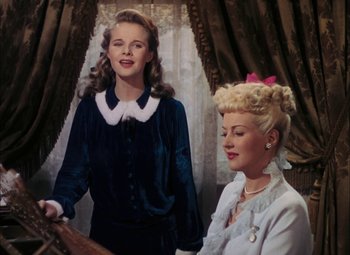 Movie still from “Mother Wore Tights” (1947), directed by Walter Lang – Two young women standing next to each other in front of a window; Medium shot, Low angle