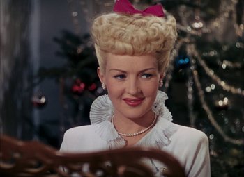 Movie still from “Mother Wore Tights” (1947), directed by Walter Lang – A woman with blonde hair and a pink bow in her hair; Close Up shot, Over the shoulder angle