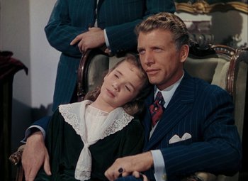 Movie still from “Mother Wore Tights” (1947), directed by Walter Lang – A man and a woman sitting next to each other on a chair; Medium shot, High angle