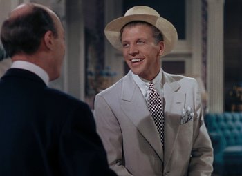 Movie still from “Mother Wore Tights” (1947), directed by Walter Lang – A man wearing a suit and a hat talking to another man wearing a suit and a hat; Medium shot, Over the shoulder angle