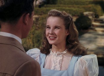 Movie still from “Mother Wore Tights” (1947), directed by Walter Lang – A woman in a blue dress smiles at a man in a brown suit; Close Up shot, Low angle