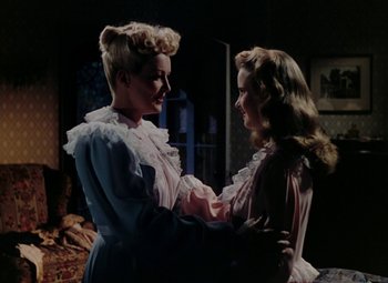 Movie still from “Mother Wore Tights” (1947), directed by Walter Lang – Two women are holding hands in a room; Medium shot, Over the shoulder angle