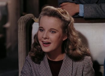 Movie still from “Mother Wore Tights” (1947), directed by Walter Lang – A young woman in a checkered jacket smiling; Close Up shot, High angle