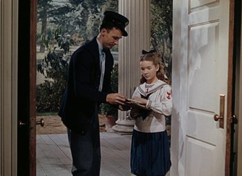 Movie still from “Mother Wore Tights” (1947), directed by Walter Lang – A man and a little girl standing next to each other on a porch; Medium shot, High angle