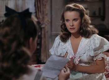 Movie still from “Mother Wore Tights” (1947), directed by Walter Lang – A woman sitting in front of a mirror holding a pen; Close Up shot, Over the shoulder angle