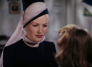 Movie still from “Mother Wore Tights” (1947), directed by Walter Lang – A woman in a black dress and a white hat; Close Up shot, Over the shoulder angle