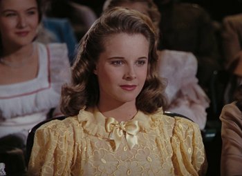 Movie still from “Mother Wore Tights” (1947), directed by Walter Lang – A young woman in a yellow dress with a bow tie; Close Up shot, Low angle