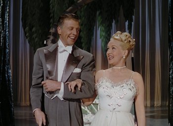 Movie still from “Mother Wore Tights” (1947), directed by Walter Lang – A man and a woman in formal wear standing next to each other; Medium shot, Low angle