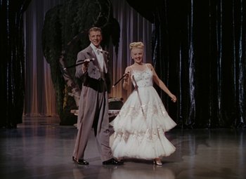 Movie still from “Mother Wore Tights” (1947), directed by Walter Lang – A man and a woman dressed in formal wear; Wide shot, Low angle