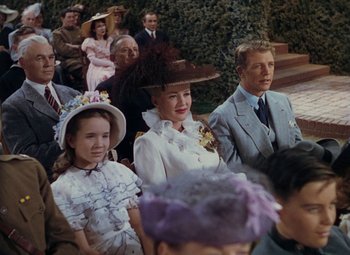 Movie still from “Mother Wore Tights” (1947), directed by Walter Lang – A group of people sitting next to each other in hats; Medium shot, High angle