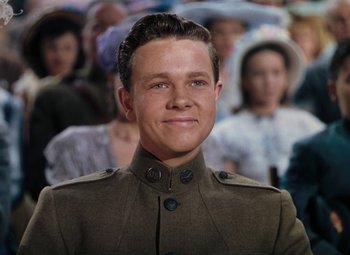 Movie still from “Mother Wore Tights” (1947), directed by Walter Lang – A man in a military uniform with a crowd behind him; Medium shot, Over the shoulder angle