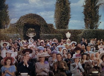 Movie still from “Mother Wore Tights” (1947), directed by Walter Lang – A large group of people wearing hats in a garden; Wide shot, High angle