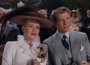 Movie still from “Mother Wore Tights” (1947), directed by Walter Lang – A man and a woman in a suit and hat; Medium shot, Low angle